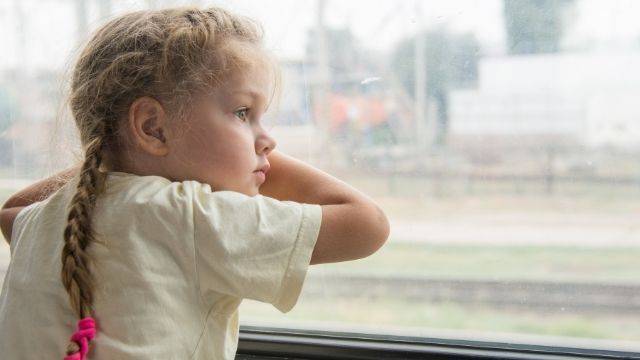niña triste en la ventana